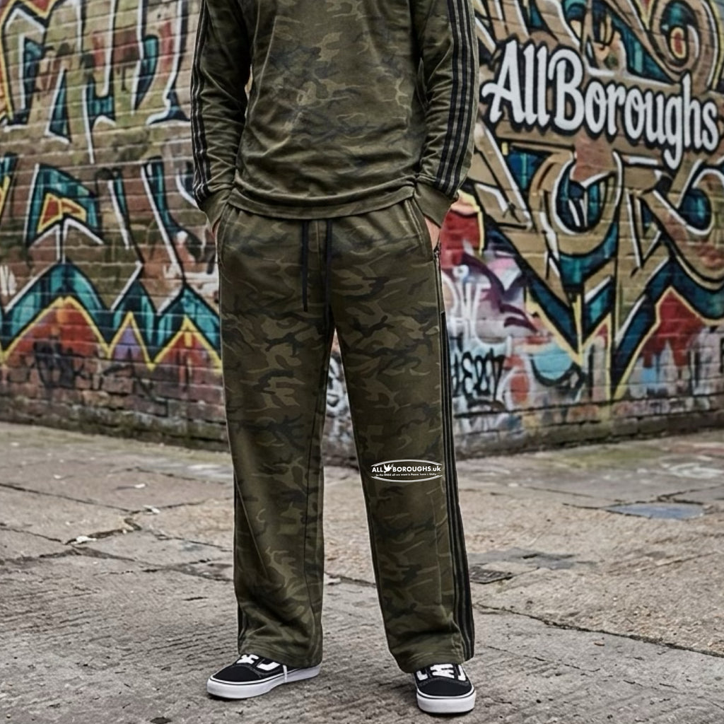 Person wearing a green camo tracksuit with 'All Boroughs' branding in front of a graffiti-covered wall.