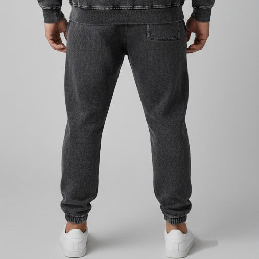 Person wearing dark gray Allboroughs sweatpants on a light gray background