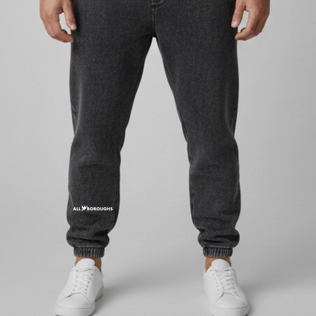 Person wearing black jogger pants with 'All Boroughs' logo on a gray background