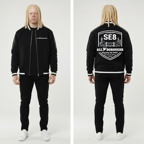 Man wearing a black tracksuit with 'London SE8 All Boroughs' branding on a white background