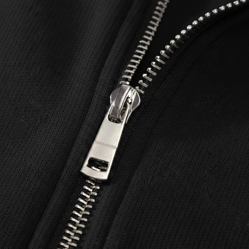 Close-up of an All Boroughs  silver zipper on a black background