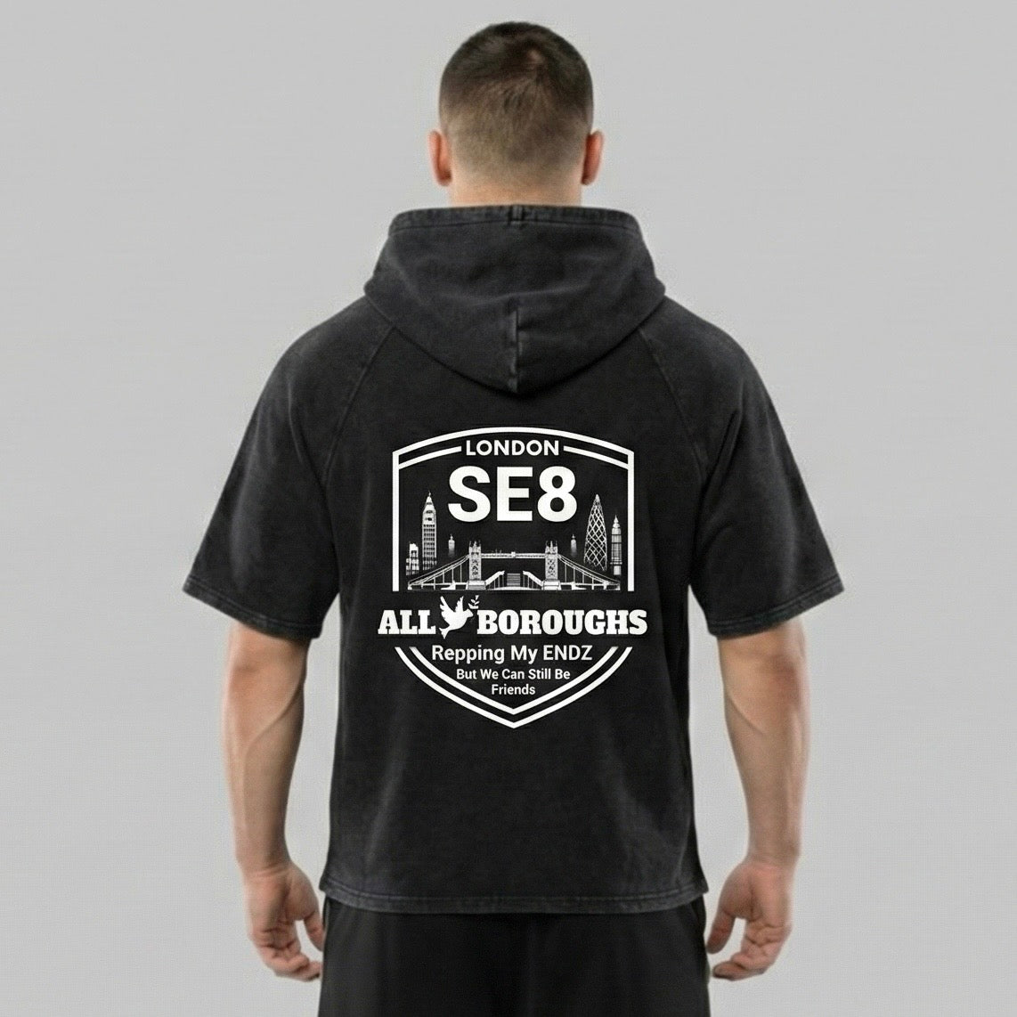 Person wearing a black hoodie with an Allboroughs white graphic and text on the back, on a gray background