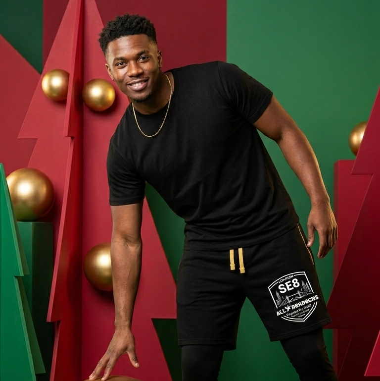 Man in black ALLBOROUGHS shorts posing with gold spheres against a colorful geometric background