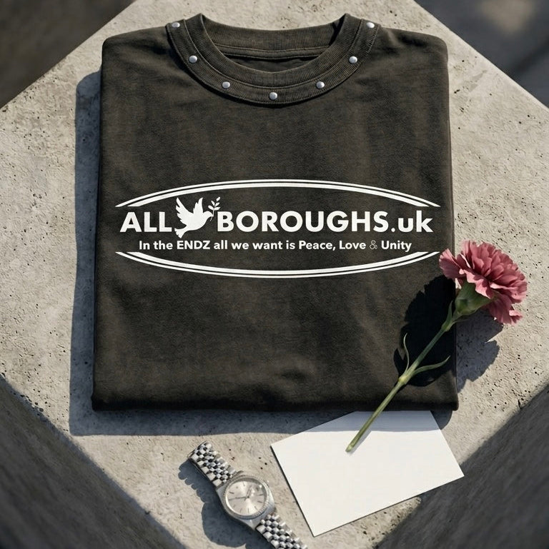Folded black ALLBOROUGHS studded sweatshirt on a concrete surface with a flower and watch.
