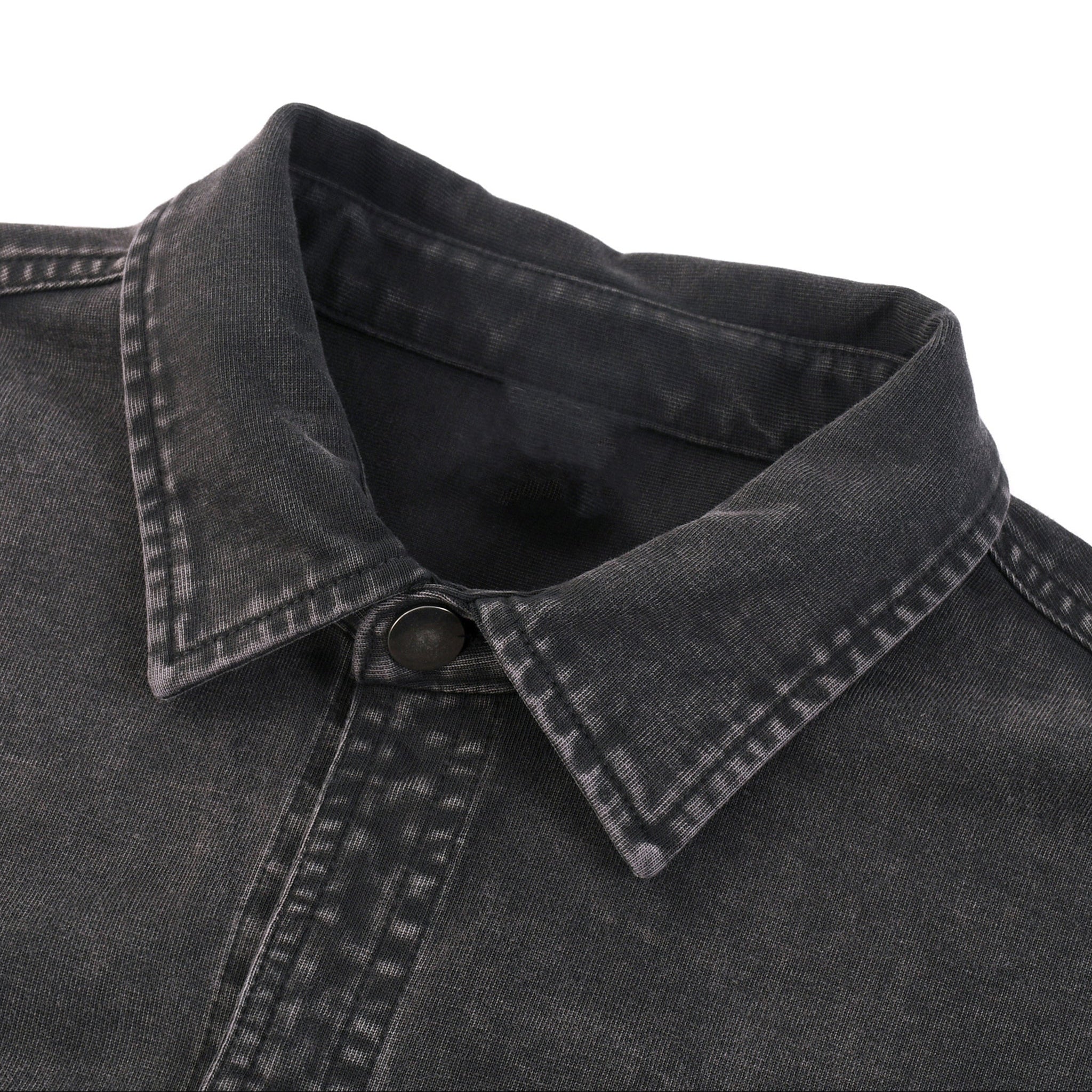 Close-up of a black denim shirt collar on a white background