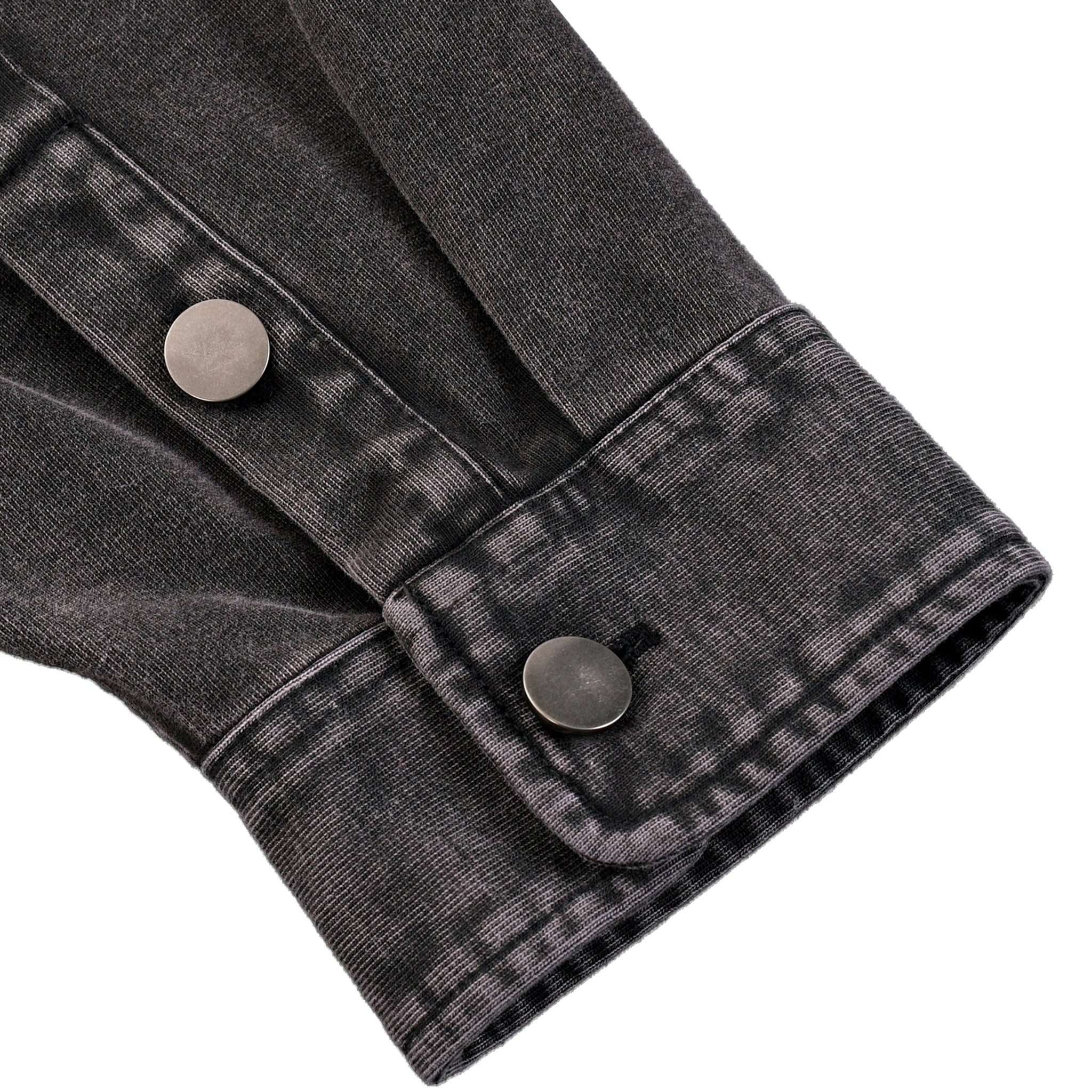 Close-up of a black denim jacket with button details on a white background